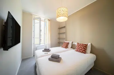 two beds in a small room with a tv at Quiet and luxurious apartment - Cannes Center - 2BR 6p in Cannes