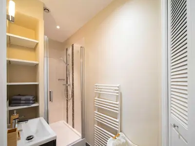a white bathroom with a shower and a sink at Quiet and luxurious apartment - Cannes Center - 2BR 6p in Cannes
