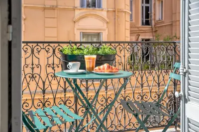 a table with a plate of food on a balcony at Quiet and luxurious apartment - Cannes Center - 2BR 6p in Cannes