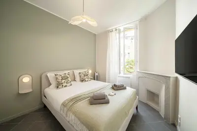 a white bedroom with a bed and a fireplace at Quiet and luxurious apartment - Cannes Center - 2BR 6p in Cannes