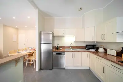 a kitchen with white cabinets and a stainless steel refrigerator at Quiet and luxurious apartment - Cannes Center - 2BR 6p in Cannes