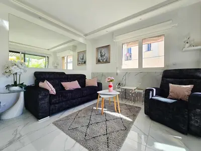 a living room with two black couches and a table at 51m2 Gray d'Albion, Croisette, terrasse & clim in Cannes