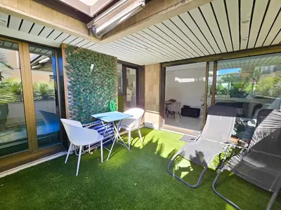 a patio with a table and chairs on the grass at 51m2 Gray d'Albion, Croisette, terrasse & clim in Cannes