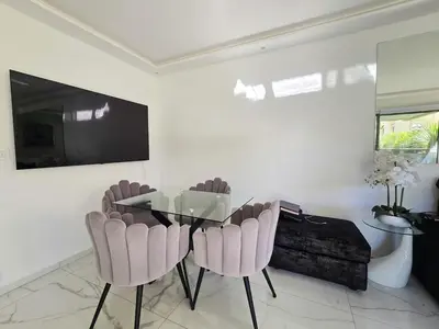 a dining room with a glass table and pink chairs at 51m2 Gray d'Albion, Croisette, terrasse & clim in Cannes