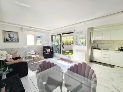 a living room with a table and chairs and a kitchen at 51m2 Gray d'Albion, Croisette, terrasse & clim in Cannes