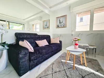 a living room with a blue couch and a table at 51m2 Gray d'Albion, Croisette, terrasse & clim in Cannes