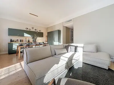 a living room with a couch and a kitchen at 66m2 Cosy appartement avec garage in Cannes