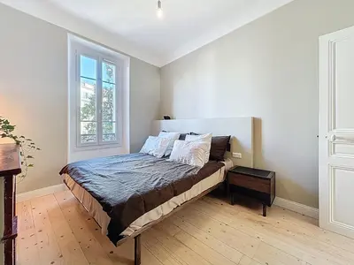 a bedroom with a bed in a room with a window at 66m2 Cosy appartement avec garage in Cannes