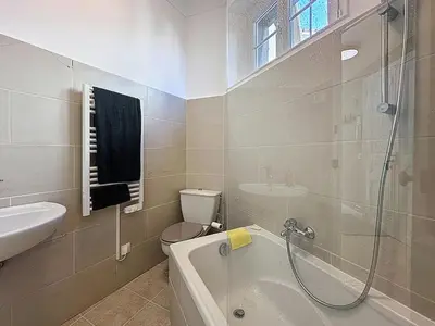 a bathroom with a tub and a toilet and a sink at 66m2 Cosy appartement avec garage in Cannes