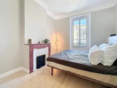 a bedroom with a bed and a fireplace at 66m2 Cosy appartement avec garage in Cannes