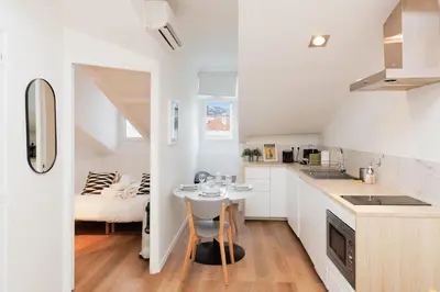 a white kitchen with a small table in the middle at Immogroom - 1 Bedroom - City Center - AC in Cannes