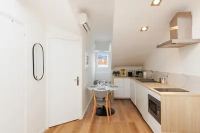 a kitchen with white cabinets and a small table at Immogroom - 1 Bedroom - City Center - AC in Cannes