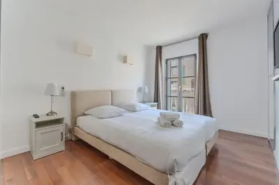 a bedroom with a bed with a teddy bear on it at Rue d Antibes 2ch, 2 SDB, clim, balcon in Cannes