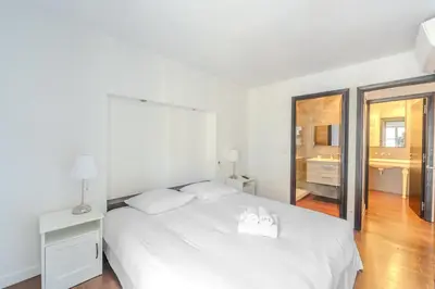 a white bedroom with a white bed and a bathroom at Rue d Antibes 2ch, 2 SDB, clim, balcon in Cannes