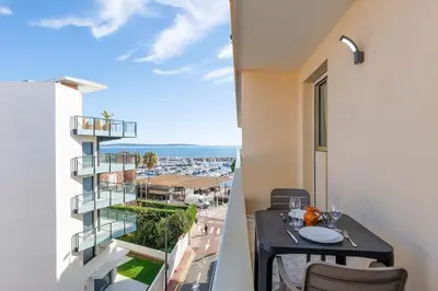 a balcony with a table and a view of a city at Immogroom - Studio - Sea View - AC in Cannes