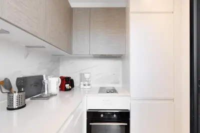 a white kitchen with a stove and a microwave at Immogroom - Studio - Sea View - AC in Cannes