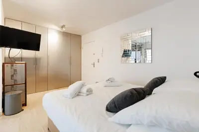 a bedroom with two beds and a flat screen tv at Immogroom – Stylish Studio – Beach 1 min away- AC in Cannes