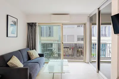 a living room with a couch and a glass table at Immogroom – Stylish Studio – Beach 1 min away- AC in Cannes