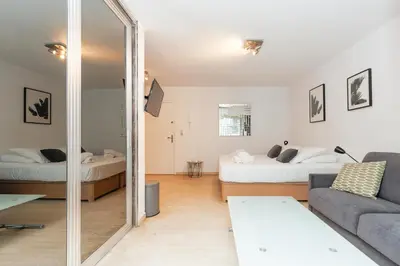 a living room with two beds and a mirror at Immogroom – Stylish Studio – Beach 1 min away- AC in Cannes