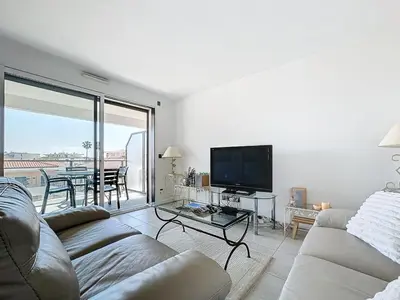 a living room with a couch and a flat screen tv at Appartement 3 pièces à Cannes avec piscine in Cannes