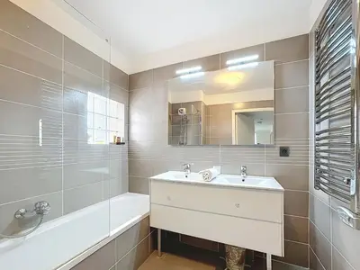 a bathroom with a sink and a tub and a mirror at Appartement 3 pièces à Cannes avec piscine in Cannes