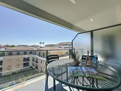 a table on a balcony with a view of a city at Appartement 3 pièces à Cannes avec piscine in Cannes