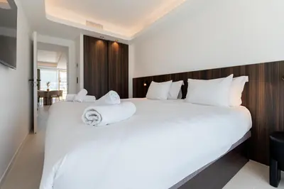a bedroom with a large white bed with towels on it at Terrasse Vue Mer - 2BR - Parking - Croisette 50m in Cannes