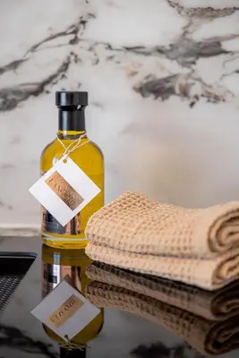 a bottle of oil next to a pile of towels at Terrasse Vue Mer - 2BR - Parking - Croisette 50m in Cannes