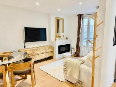 a living room with a tv and a table at Repère des Artistes - central, 3mn from Beach, 10mn Palais, modern, AC, balcony in Cannes