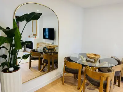 a dining room with a glass table and a mirror at Repère des Artistes - central, 3mn from Beach, 10mn Palais, modern, AC, balcony in Cannes