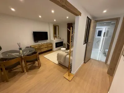 a living room with a dining table and a television at Repère des Artistes - central, 3mn from Beach, 10mn Palais, modern, AC, balcony in Cannes