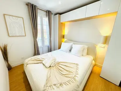 a bedroom with a white bed with a bow on it at Repère des Artistes - central, 3mn from Beach, 10mn Palais, modern, AC, balcony in Cannes