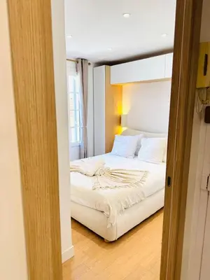 a bedroom with a bed in a room with a mirror at Repère des Artistes - central, 3mn from Beach, 10mn Palais, modern, AC, balcony in Cannes