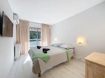 a bedroom with a bed and a large window at Rue d'Antibes Victoria 2 rooms terrace - 2ES in Cannes