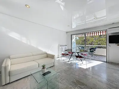 a living room with a white couch and a table at Rue d'Antibes Victoria 2 rooms terrace - 2ES in Cannes