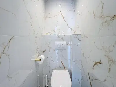 a bathroom with a toilet and a marble wall at Rue d'Antibes Victoria 2 rooms terrace - 2ES in Cannes