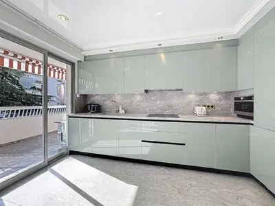 a kitchen with white cabinets and a large window at Rue d'Antibes Victoria 2 rooms terrace - 2ES in Cannes