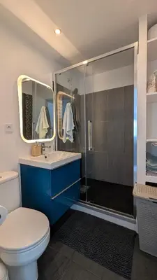 a bathroom with a blue sink and a shower at Pleasant bright apartment - lake and pool view in Le Cannet