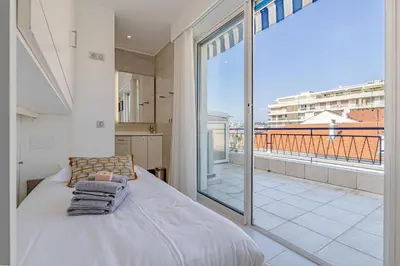 a bedroom with a bed and a large window at 6 LECERF T5 - Apartment heart of Cannes 4 Bedrooms Terrace in Cannes