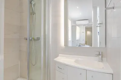 a white bathroom with a sink and a shower at 6 LECERF T5 - Apartment heart of Cannes 4 Bedrooms Terrace in Cannes
