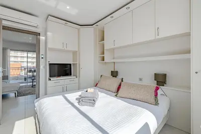 a white bedroom with a bed and a tv at 6 LECERF T5 - Apartment heart of Cannes 4 Bedrooms Terrace in Cannes