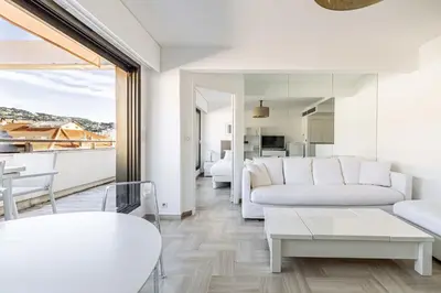 a living room with a couch and a table at 64 ANTIBES - Stunning 1-bedroom with terrace at Gray d'Albion in Cannes