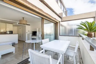 a kitchen and dining room with white tables and chairs at 64 ANTIBES - Stunning 1-bedroom with terrace at Gray d'Albion in Cannes