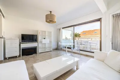 a living room with a white couch and a table at 64 ANTIBES - Stunning 1-bedroom with terrace at Gray d'Albion in Cannes