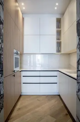 a kitchen with white cabinets and a wooden floor at 106 ANTIBES - Luxurious 4-bedroom apartment Rue d'Antibes in Cannes