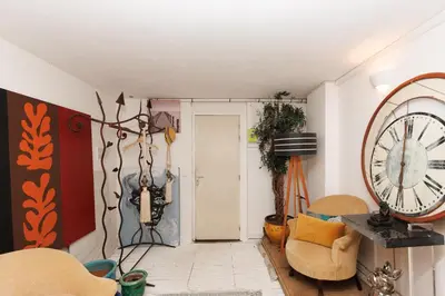 a living room with a large clock on the wall at Loft Gallia YourHostHelper in Cannes