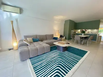 a living room with a couch and a rug at Cannes - Magnifique 4 pièces terrasse au calme à deux pas de la rue d'Antibes in Cannes