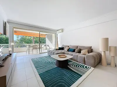 a living room with a couch and a table at Cannes - Magnifique 4 pièces terrasse au calme à deux pas de la rue d'Antibes in Cannes