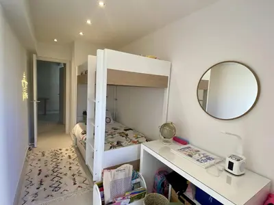 a small bedroom with a bunk bed and a mirror at Cannes - Magnifique 4 pièces terrasse au calme à deux pas de la rue d'Antibes in Cannes