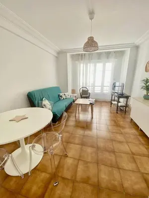 a living room with a couch and a table at Cannes proche Croisette - 2 pièces lumineux in Cannes